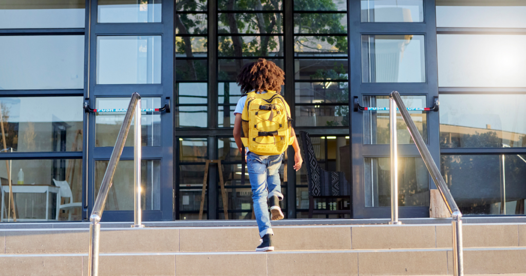 child with backpack entering building about to go through school security screening