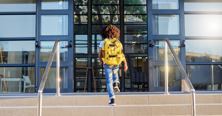 child with backpack entering building about to go through school security screening